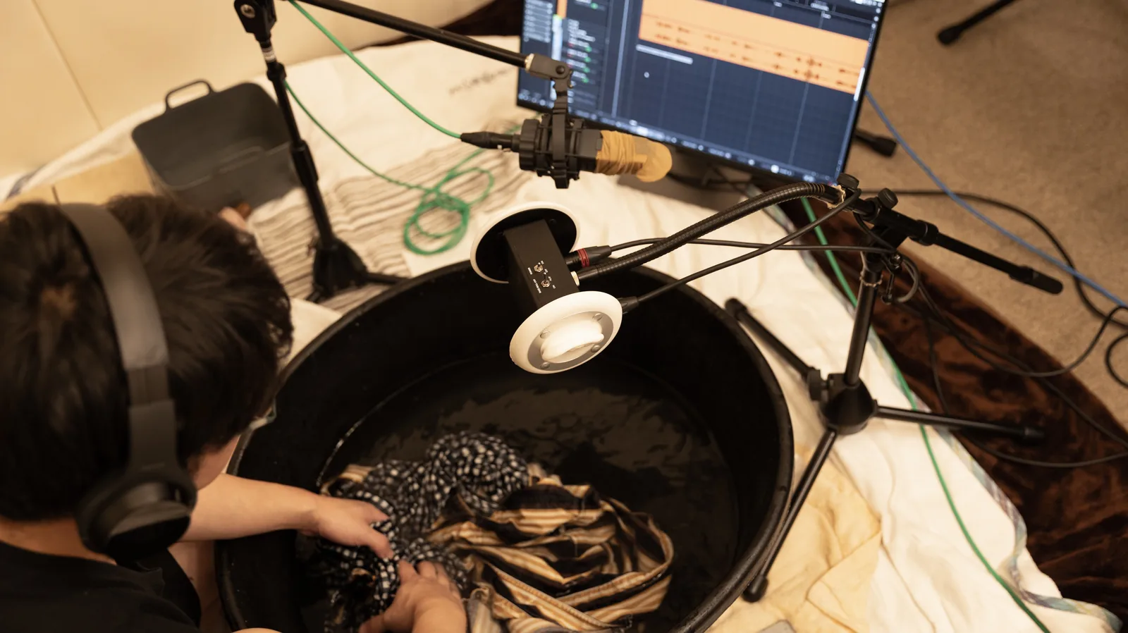 ヘッドホンでモニターしながら効果音を収録するスタッフ